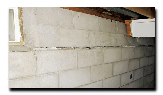 Bowed cement wall with horizontal crack  running along the cemen